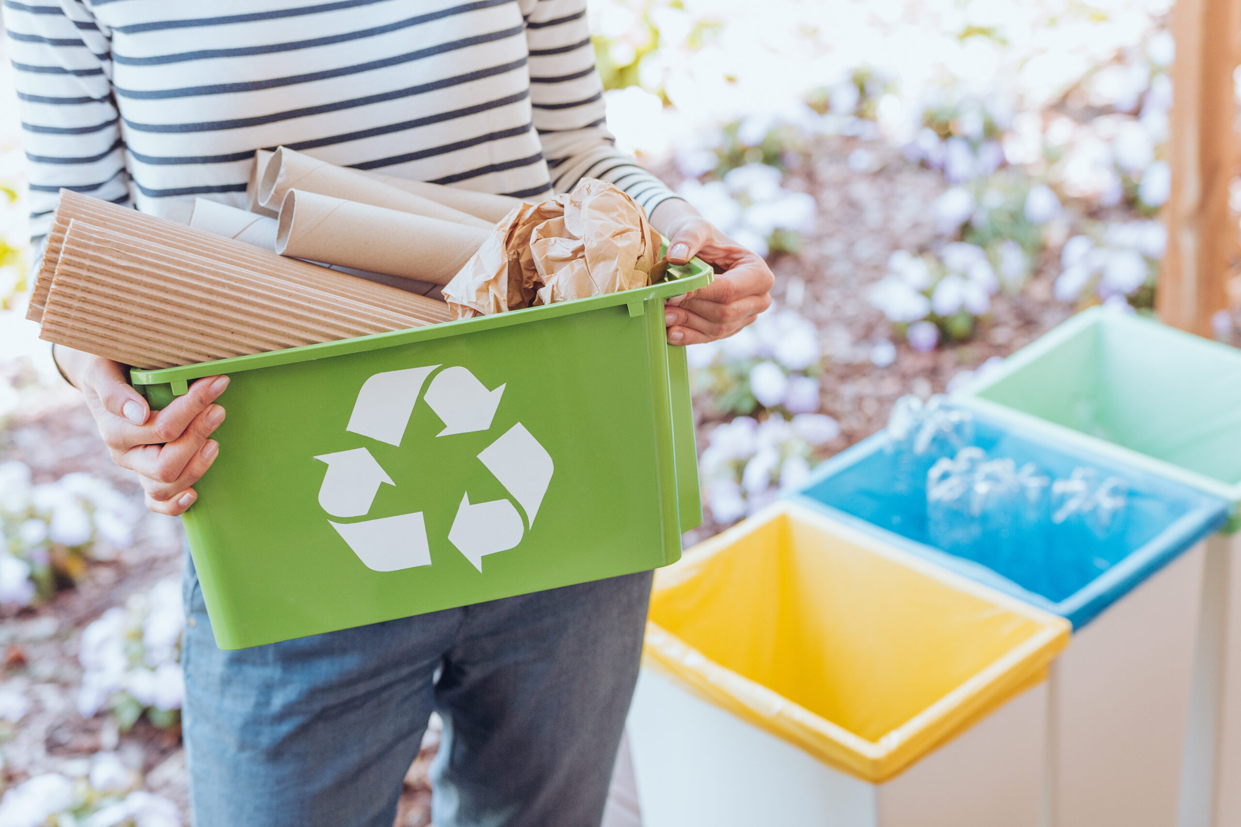 Usager prenant soin de l’environnement lors du tri des déchets de papier vers la poubelle de recyclage appropriée sur la terrasse