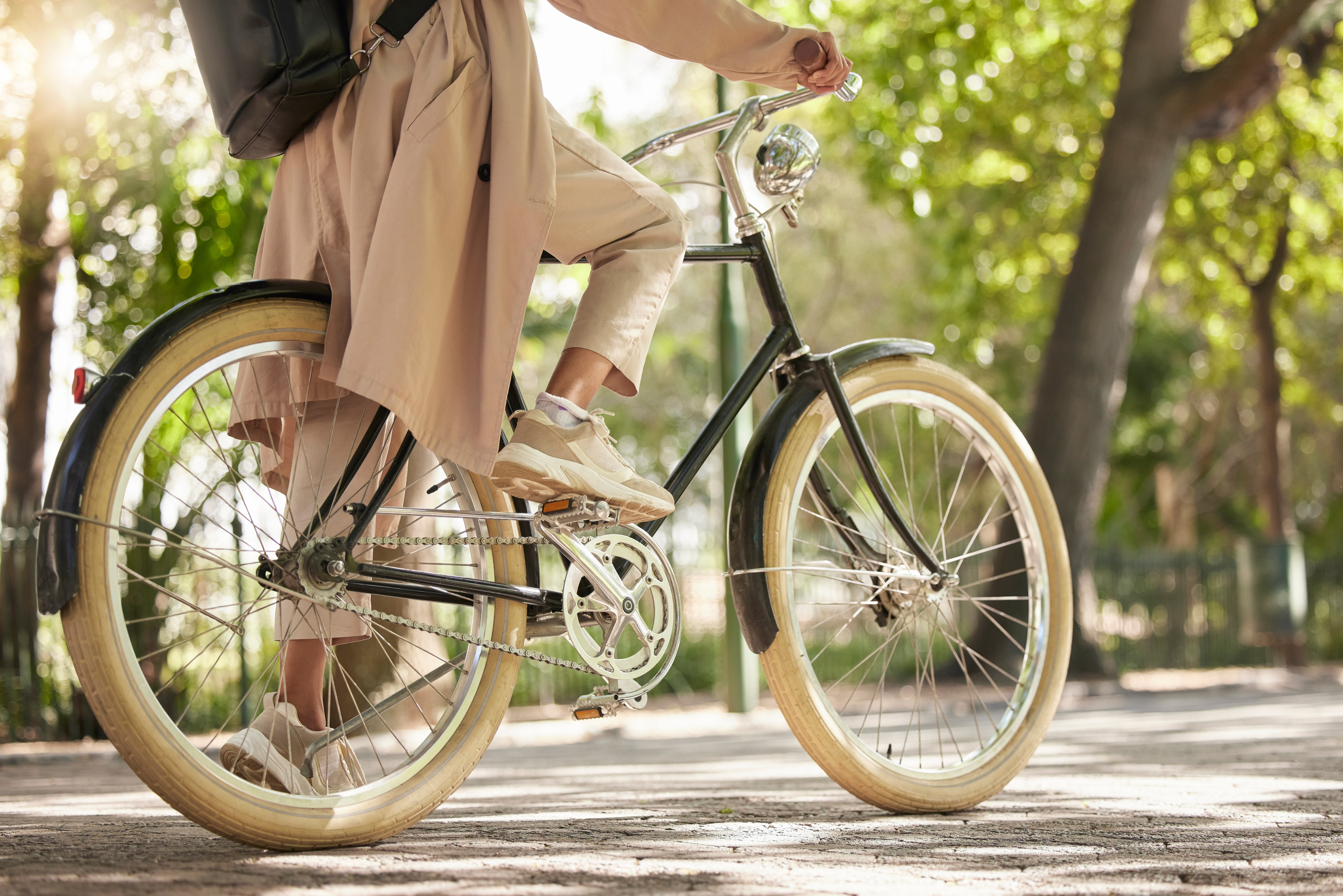 Vélo, gros plan et pieds de cycliste occasionnel se déplaçant sur un vélo dans un parc en plein air dans la nature pour une balade ou un trajet. L’exercice, le bien-être et le mode de vie étudiant le vélo comme moyen de transport durable
