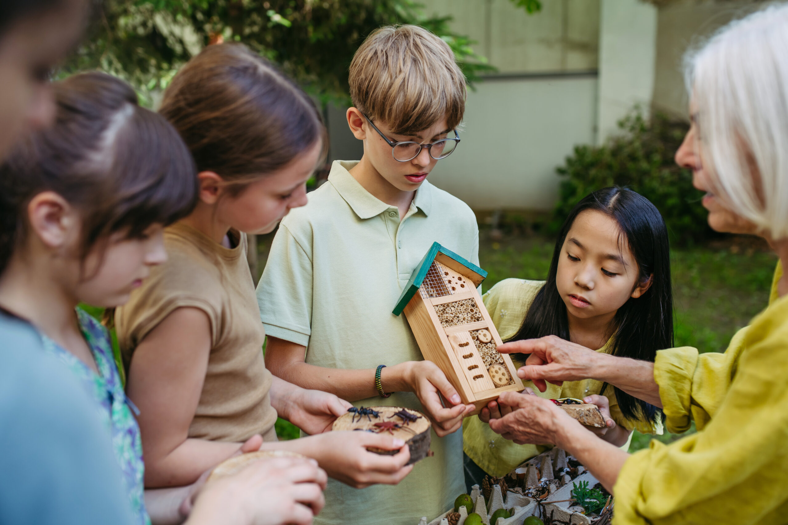 L’hôtel à insectes comme outil pédagogique pour les enfants en classe éducative durable en plein air. Jeunes étudiants s’initiant aux insectes et à la biodiversité.